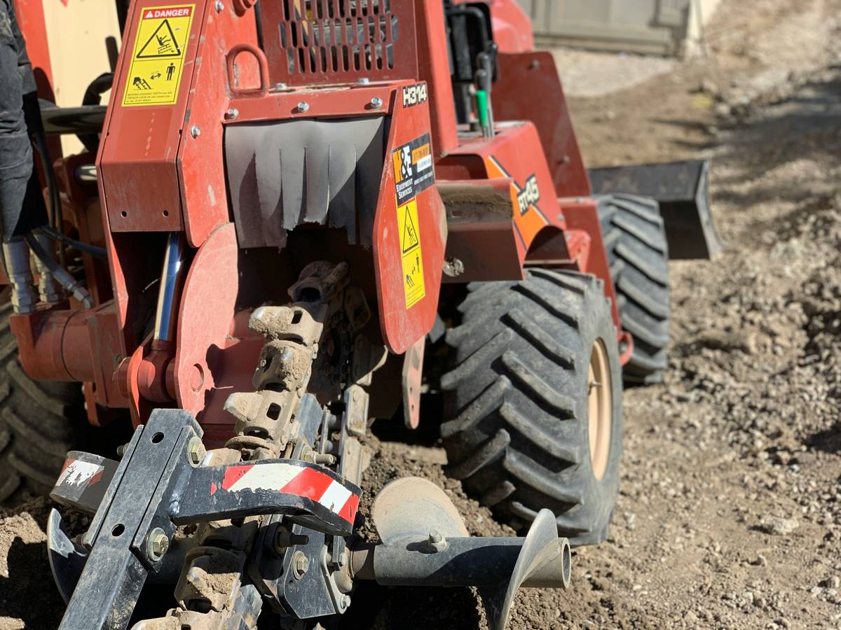 Close-up of a field cultivator tilling garden soil with what is a field cultivator labeled
